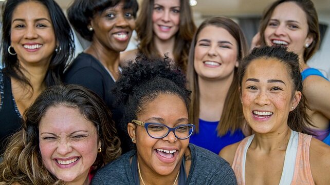 A close-up of a large group of smiling women looking at the camera