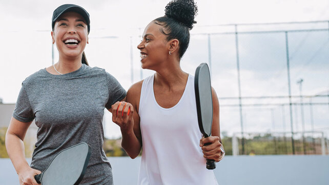 Two women playing laughing after playing pickleball