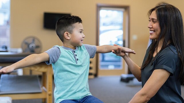 A young child receiving pediatric rehabilitation services.