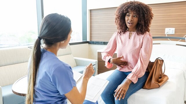 Woman talking to a doctor about abdominal pains.