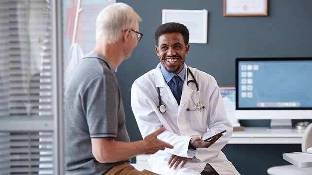 Older male patient speakign to a pulmonary doctor.