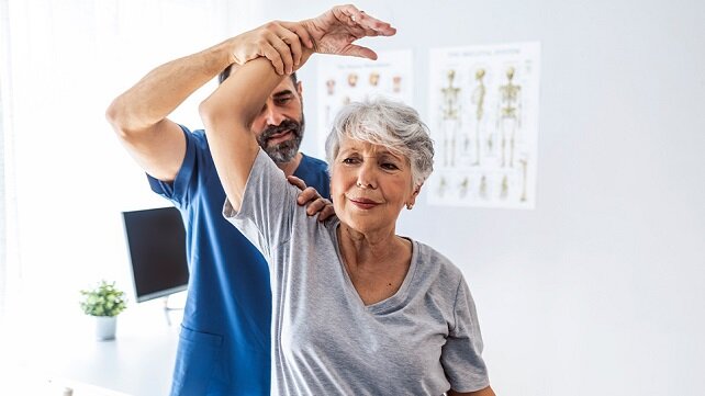Older woman receiving physical therapy/rehab services.
