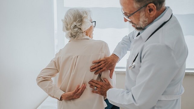 A doctor checking a patient's spine.