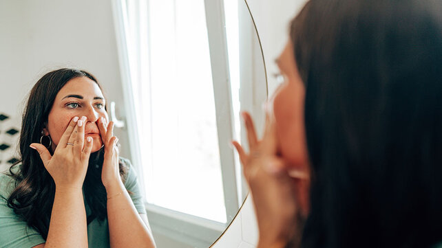 Women washing face in mirror