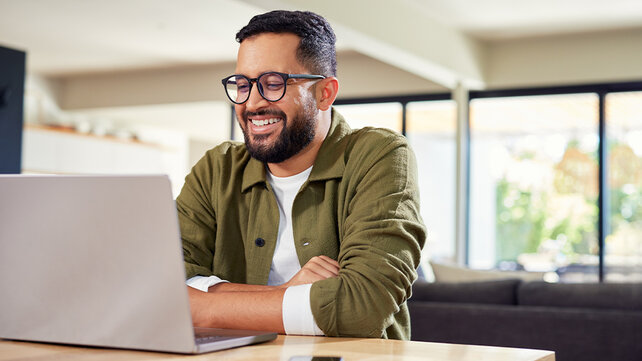 A man sits typing on his laptop.