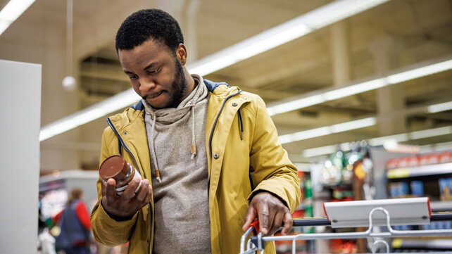 Man looking at food label grocery store