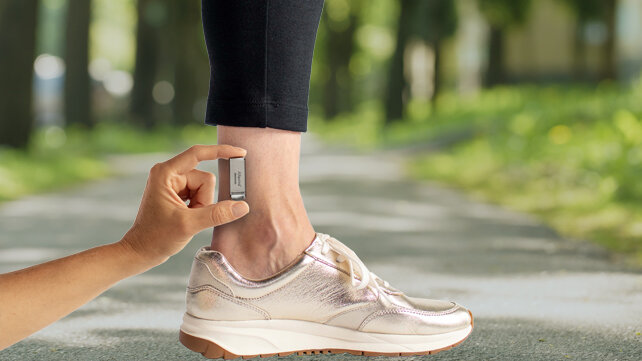 An Altaviva device compared to the size of a woman's ankle.