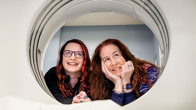 Two clinicians looking through a testing machine.