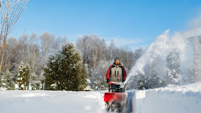 Man pushing snowblower in snow