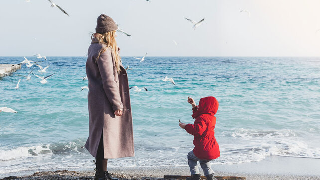 Mother and child on beach in winter