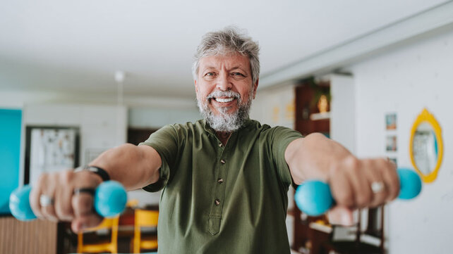 Man smiling lifting weights