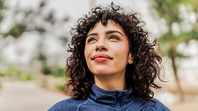 A woman smiles up at the sky.