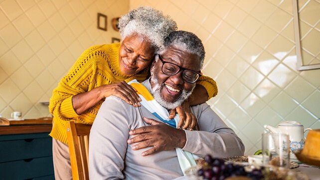 Older couple embracing in their kitchen