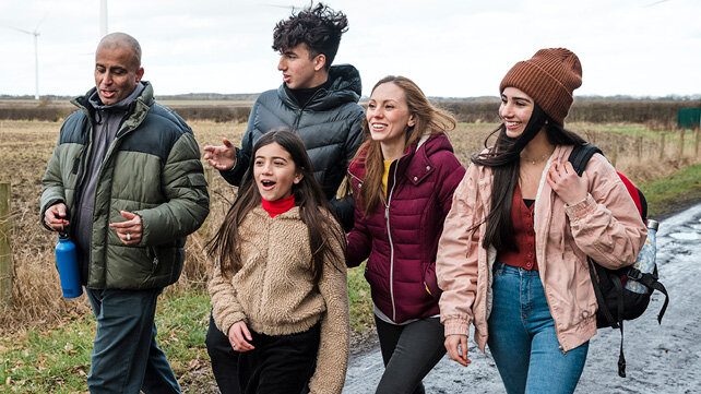 Happy and smiling family with teenagers outside enjoying a walk