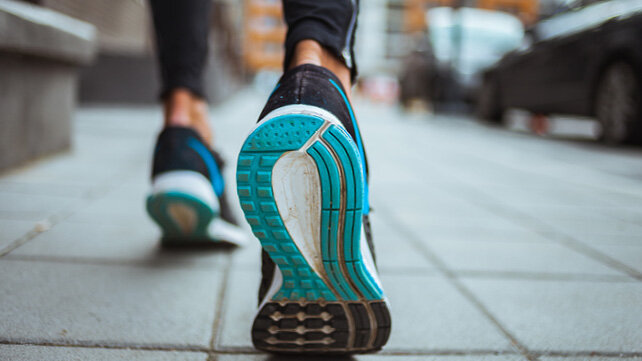 The back of someone's athletic sneakers as they're walking.