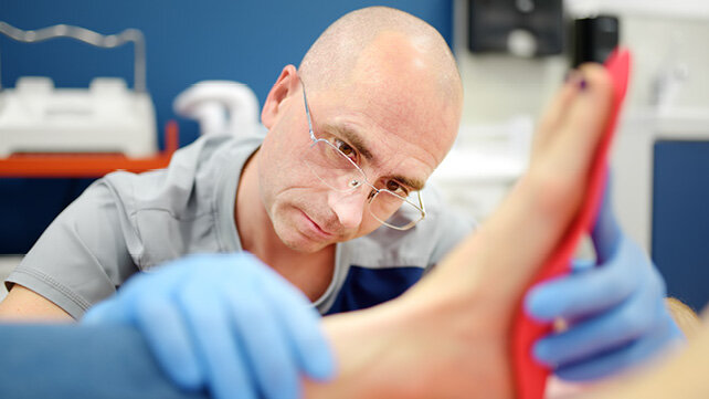 A podiatrist examining a patient's foot.