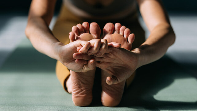 Photo from the front of a person stretching. 
