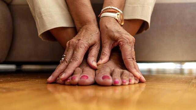 Close-up of a a woman's hands massaging her bare feet