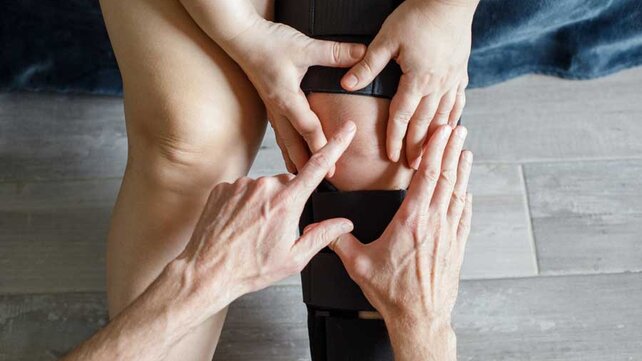 Person with knee brace and provider pointing to knee
