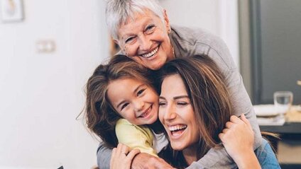 Three generations of women hugging and smiling