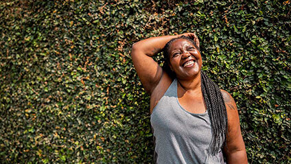 Bariatric Surgery Patient Posing With Arm Up in Front of Ivy Wall